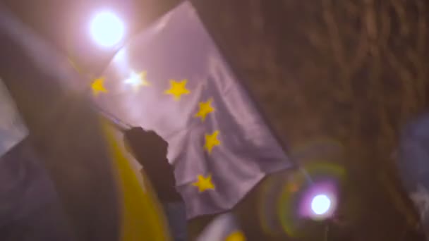 Kiev, Oekraïne - Circa December 2014: Euromaidan demonstraties. Vrouwelijke demonstrator houden van vlaggen van Oekraïne en de Eu als symbool van solidariteit — Stockvideo