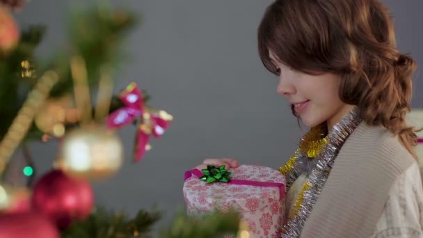 Niña morena abriendo regalo de Navidad y sonriendo, milagro y magia — Vídeos de Stock