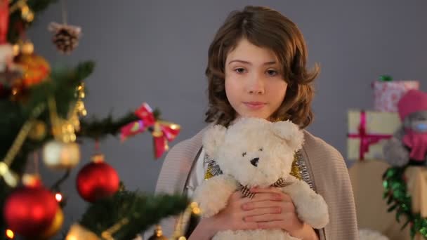 孤児の少女の願い、子供の頃、休日をしてクリスマス ツリーの近くに立って — ストック動画
