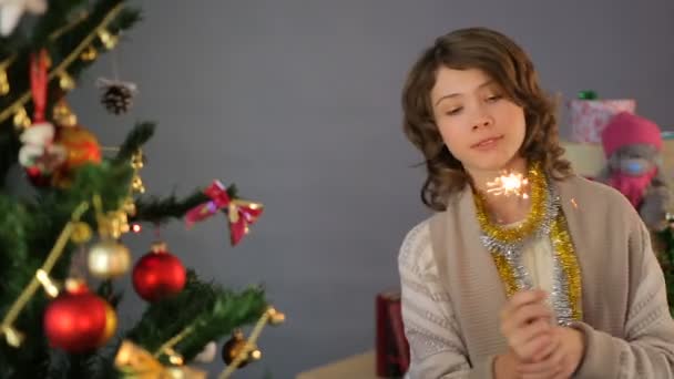 Feliz niña bailando con espumoso cerca del árbol de Navidad en casa, celebración — Vídeos de Stock