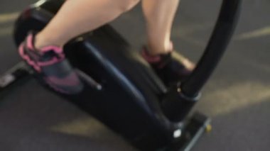 Sağlıklı ince kadın giyiyor fitness bilezik binme egzersiz bisikleti Spor Kulübü