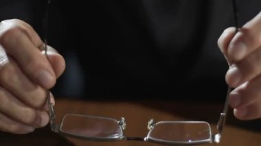 Eller gözlük tutan ve masanın üzerine koyarak yetişkin işadamı avukat