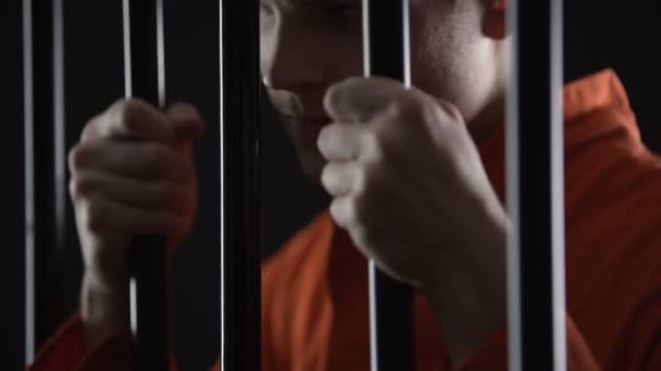 Подозреваемый в тюрьме в ожидании суда, нетерпеливый и нервный, надеется избежать наказания — стоковое видео