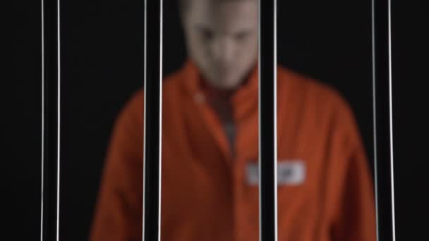 Arrested man in orange suit approaching to prison bars, death penalty judgment — Stock Video