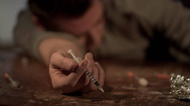 Yüksek uyuşturucu bağımlısı enjeksiyon sonra baygın yatıyor elinde şırınga, aşırı doz