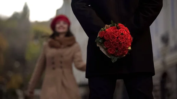 Homem à espera de namorada, segurando flores, primeiro encontro, início de relações — Fotografia de Stock