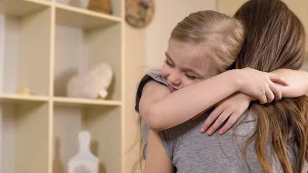 Little girl firmly and with love hugging her mother, warm relations, childhood — Stock Photo, Image