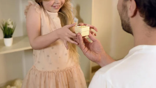 Pai amoroso apresentando filha surpresa com bom presente, infância feliz — Fotografia de Stock