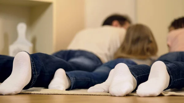 Perfect family lying on floor together, enjoying weekend leisure, happy memories