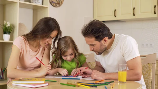 Щаслива сім'я малює разом, люблячі батьки насолоджуються відпочинком з дочкою — стокове фото