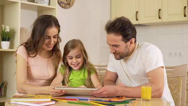 Happy family viewing photos on tablet, girl sliding pictures on touchscreen — Stock Photo, Image