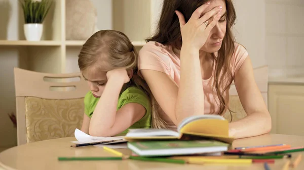 Triste filha e mãe tendo conflito fazendo muito trabalho de casa duro e chato — Fotografia de Stock