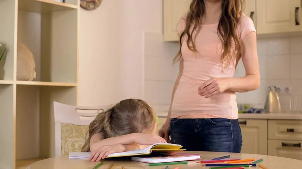 Überbehütende Mutter kontrolliert kleine Tochter und lässt sie langweiliges Buch lesen — Stockfoto