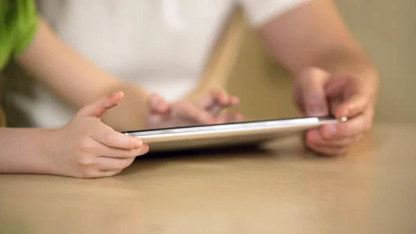 Handen van meisje typen op tablet touchscreen, vader en dochter die met behulp van de app — Stockfoto