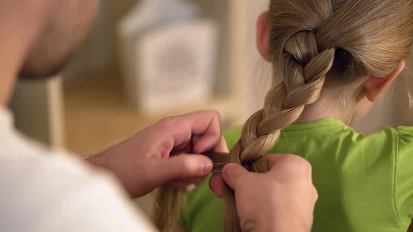 Father braiding daughters hair carefully, taking care of beloved kid, family — Stock Photo, Image