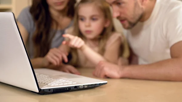 Family using laptop for shopping, booking tickets online or viewing pictures — Stock Photo, Image