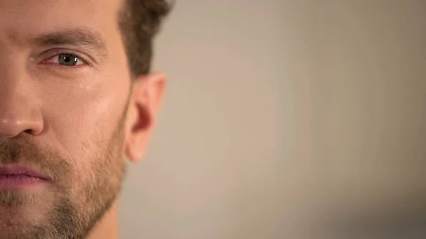 Hombre joven medio cara mirando a la cámara, encuesta de opinión del hombre promedio, estadísticas — Foto de Stock