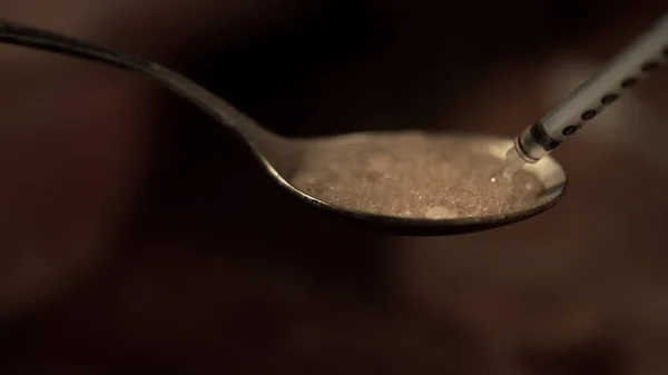 Seringa retirando a heroína fervendo na colher, dependência de substância, close-up — Fotografia de Stock