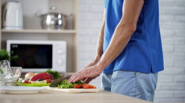 Erkek Şef yeşil salata yaprakları mutfak bıçağıyla sağlıklı yemek için kesme.