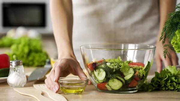 Taze salata, baharat için zeytin yağı soyunma kase tutan genç karısı diyet