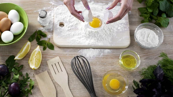Kvinnlig kock att lägga ägg i mjöl, förbereda degen för att göra hemlagade pannkakor — Stockfoto