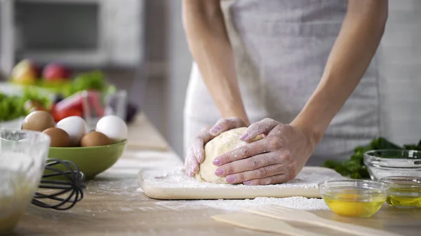 Caring mother kneading the dough at the kitchen, woman making cakes, top-view — Stock Photo, Image