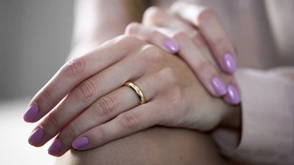 Close-up de mãos femininas deitadas de joelhos com anel de noivado de ouro, jóias — Fotografia de Stock