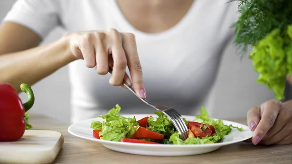 Young lady taking tomato salad fork from dinner plate, healthy snack, vitamins — Stock Photo, Image