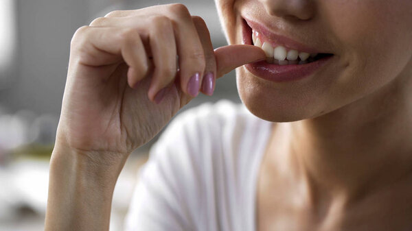 Woman enthusiastically gnawing nails attentively, hearing companion, bad habits