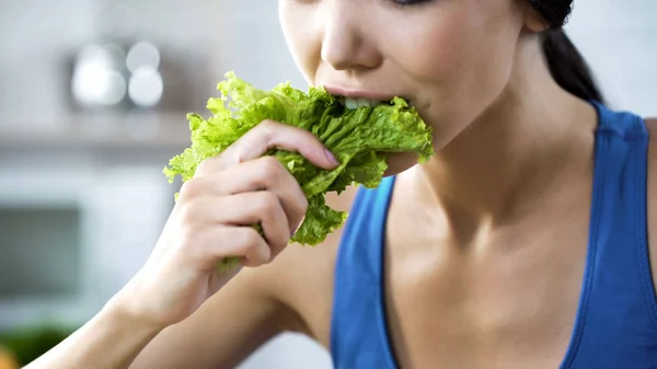 Deseando perder peso y ser delgada, señora haciéndose comer lechuga, nutrición — Foto de Stock