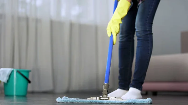 Ama de casa lavando cuidadosamente el piso en su apartamento con fregona, limpieza de primavera — Foto de Stock