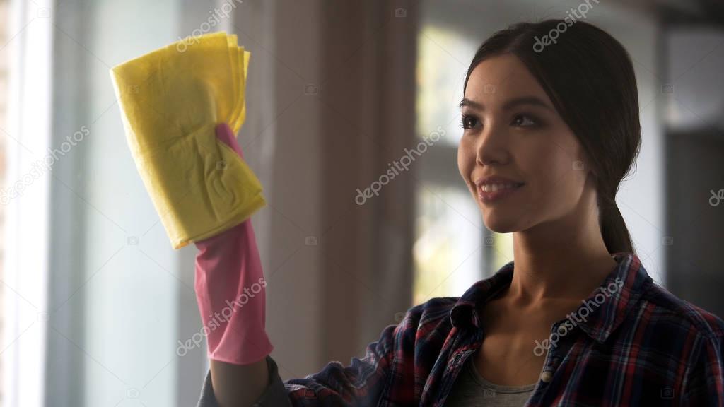 Adult daughter helping mother in general cleaning, washing windows, house chores