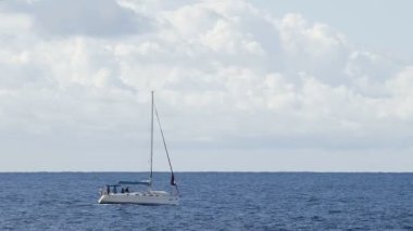Mavi deniz altında bulutlu gökyüzü, rekreasyon genelinde yelken furled yelkenli tekne