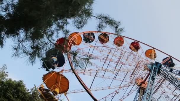 Ferris wiel langzaam draaien in stadspark, passagiers zitten cabine, onderste weergave — Stockvideo