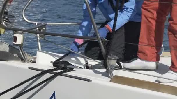 Люди на борту, привязывающие лодку к причалу, готовящиеся к морскому путешествию, активный летний отдых — стоковое видео