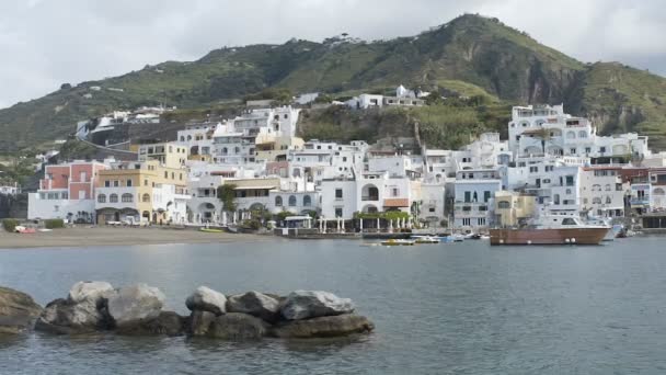 Kustnära vita hus byggt uppförsbacke inför liten vik, ön Ischia i Italien — Stockvideo