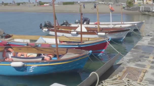 Ischia, italien - ca. Juli 2014: Menschen auf der Insel. Motorboote an Anlegesteg mit Seilen gefesselt, Mann überprüft Motor, Angeln — Stockvideo