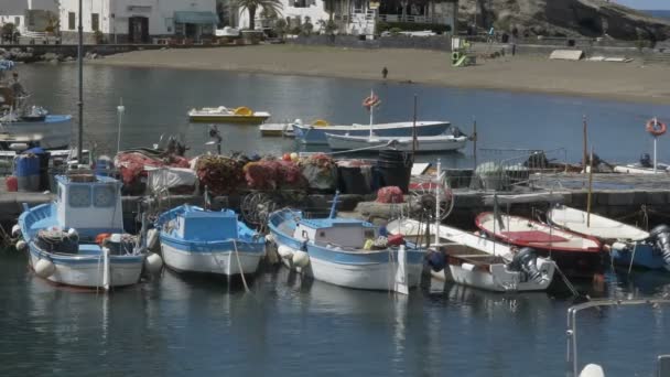 Small bay with docked speedboats, fishing nets lying on mooring, seaside village — Stock Video