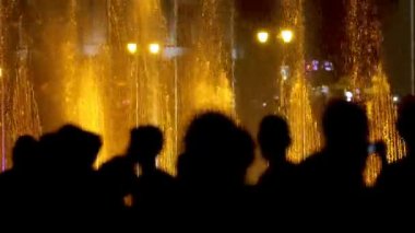 Turistler hayran çeşme geceleri siluetleri ön planda aydınlatılmış