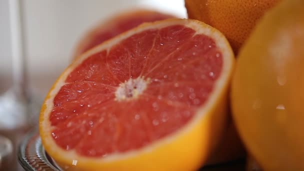 Свежие грейпфруты на тарелке, приготовленный праздничный стол с фруктами крупным планом — стоковое видео