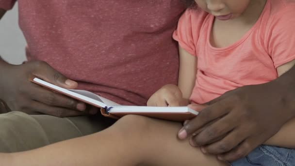 Padre cariñoso enseñando a su hija a leer, educación en el hogar, desarrollo temprano — Vídeo de stock
