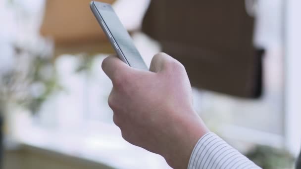 Hand van de mens scrollen webpagina's op de smartphone, lezen van zakelijk nieuws online — Stockvideo