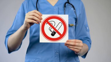 Nurse holding in hands no smoking card, harmful habit, medicine and healthcare clipart