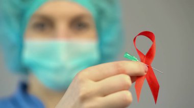 Kadın doktor kırmızı kurdele şırınga iğnesi, HIV AIDS bilinçlendirme sembolü holding