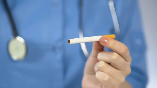Γυναίκα γιατρός εκμετάλλευση τσιγάρο στο χέρι, τον εθισμό επιβλαβής συνήθεια, τον κίνδυνο εμφάνισης καρκίνου — Φωτογραφία Αρχείου