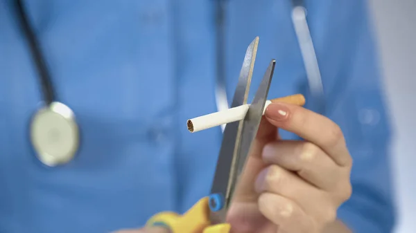 Médicos mãos cortando cigarro com tesoura, campanha anti-tabaco, mau hábito — Fotografia de Stock