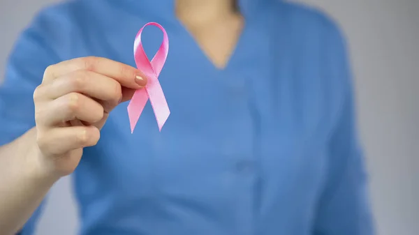 Врач показывает розовую ленту крупным планом, кампанию против рака молочной железы, обследование — стоковое фото