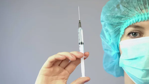 Female anesthetist holding syringe with medicine and preparing for surgery — Stock Photo, Image