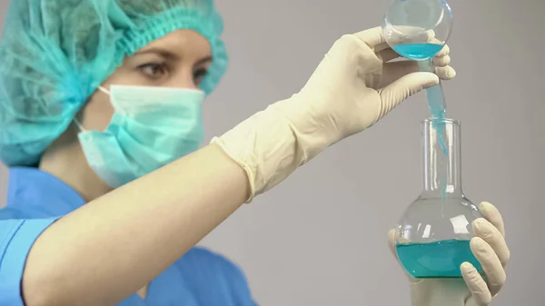 Pesquisador fazendo experiência em laboratório misturando dois líquidos, medicamento, vacina — Fotografia de Stock