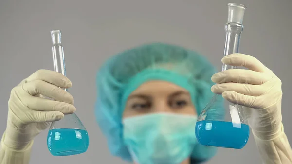 Investigador médico sosteniendo tubos de ensayo con líquido en las manos, investigación de laboratorio — Foto de Stock